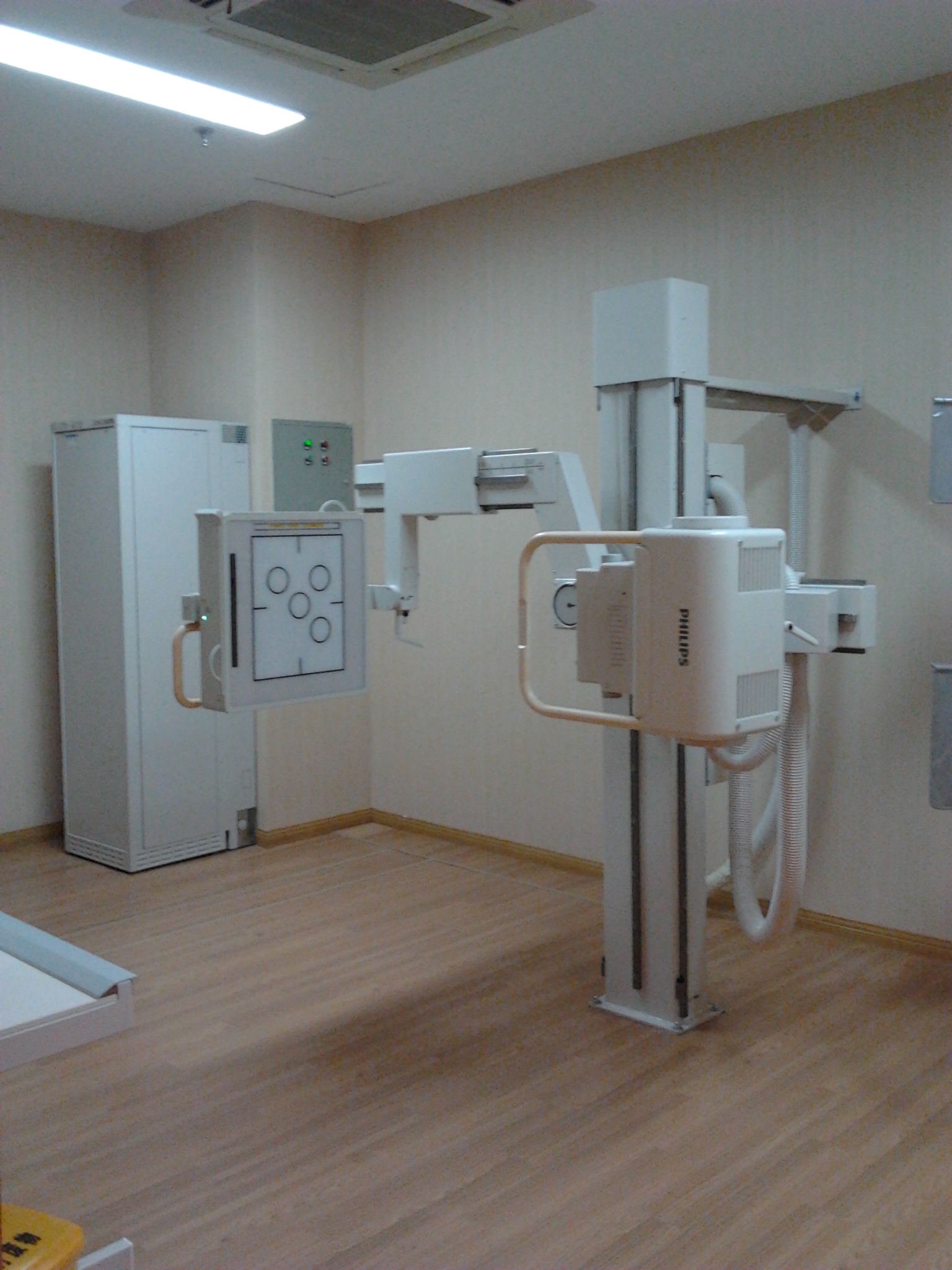 Digital X-ray tube and upright detector in a radiography room